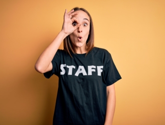 young-beautiful-worker-woman-wearing-staff-uniform-tshirt-isolated-yellow-background-doing-ok-gesture-shocked-with-surprised-face-eye-looking-through-fingers-unbelieving-expression