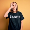 young-beautiful-worker-woman-wearing-staff-uniform-tshirt-isolated-yellow-background-doing-ok-gesture-shocked-with-surprised-face-eye-looking-through-fingers-unbelieving-expression